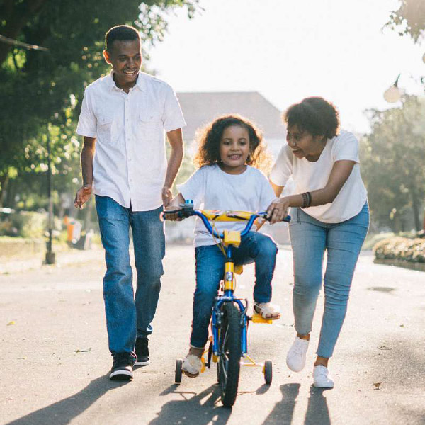 Moving to Canada with your family - child riding a bike with parents