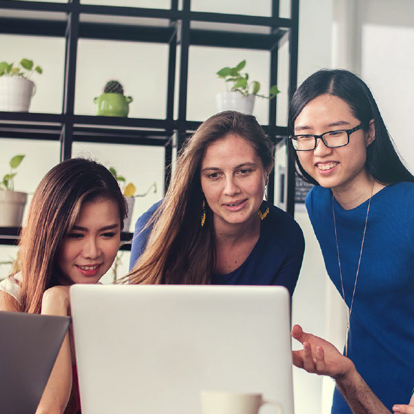 Group of girls around a computer studying in Canada